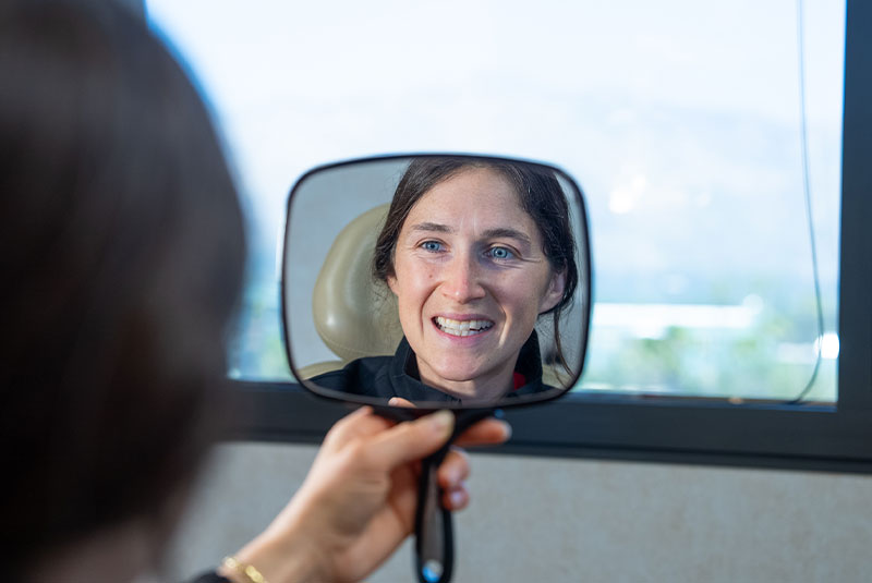 Paitent looking into mirror after dental Procedure