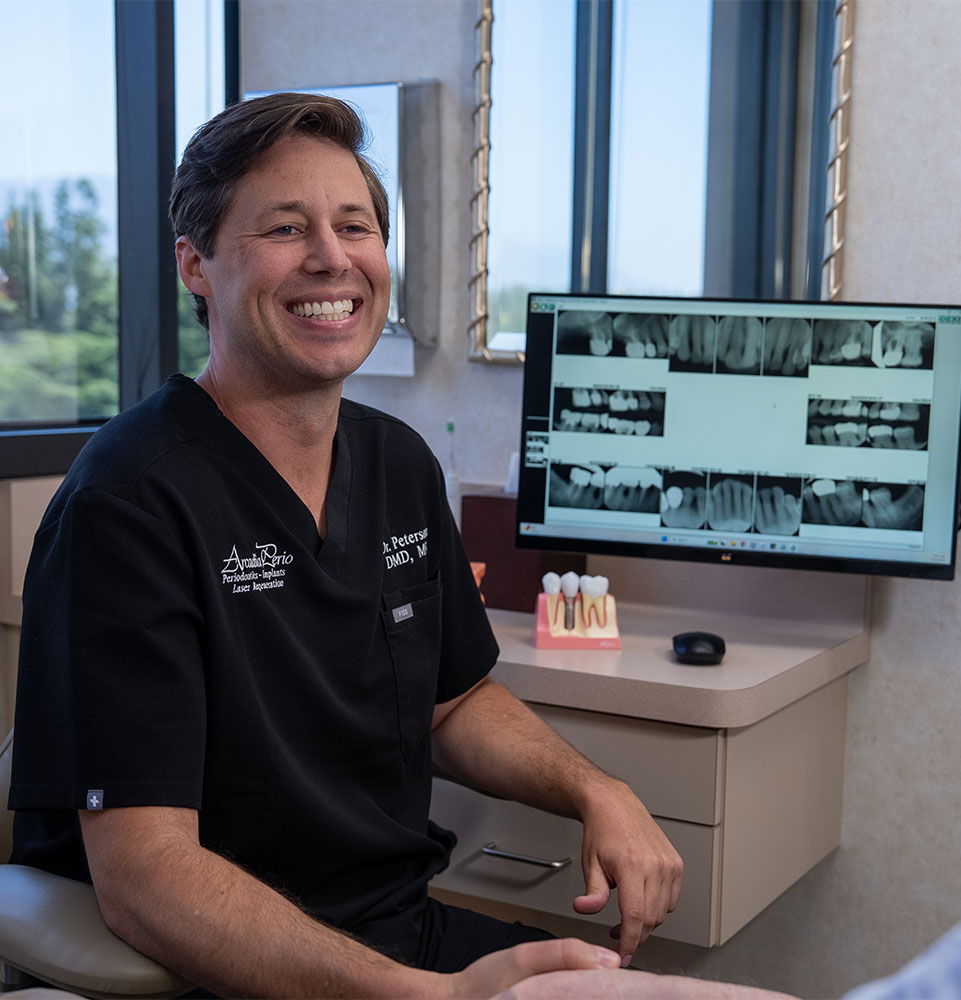 doctor smiling brightly while going over dental procedure