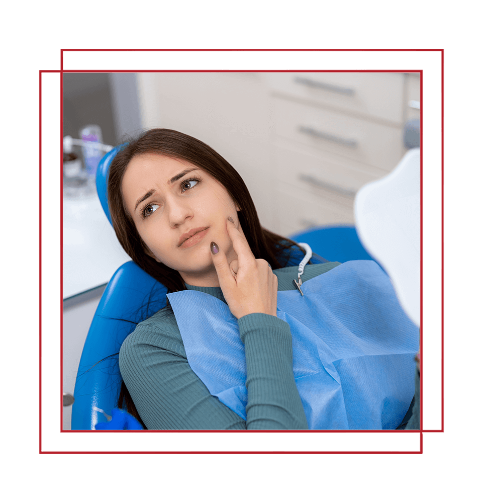 Patient has dental discomfort. A young woman at the dentist shows signs of discomfort