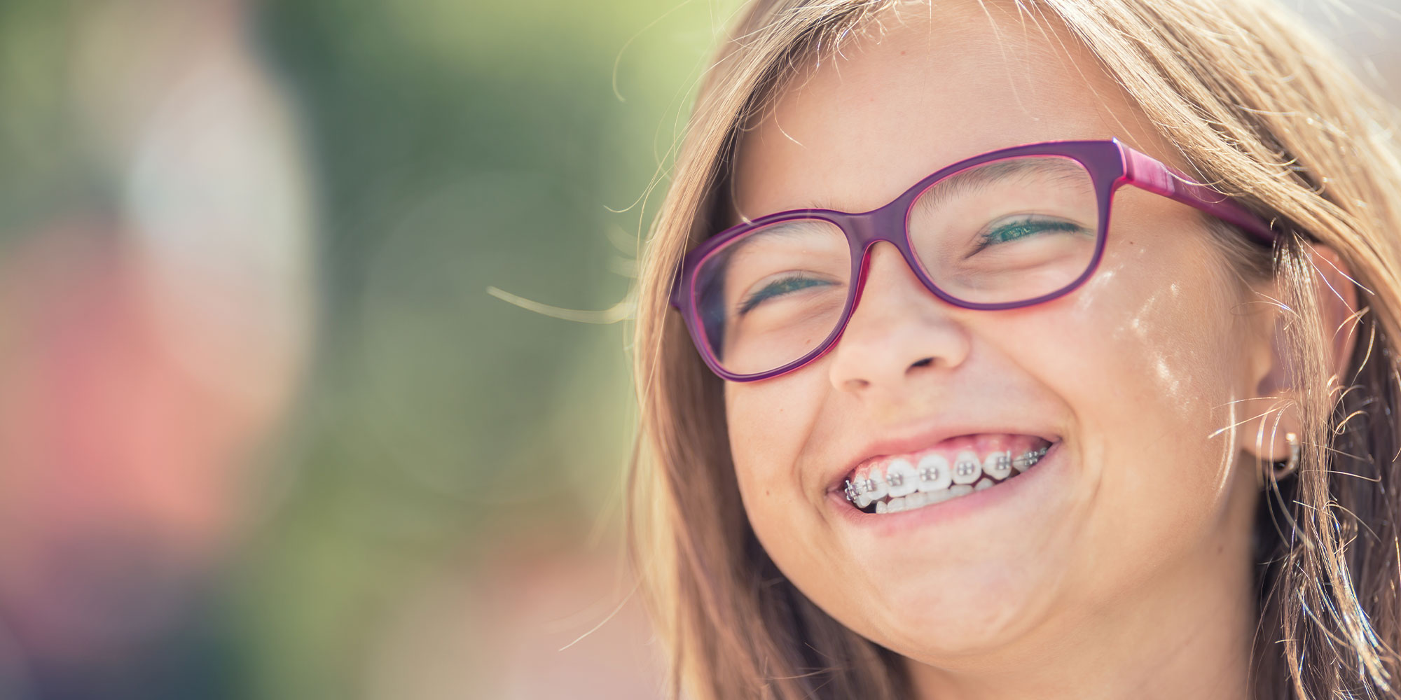 Portrait of a happy smiling teenage girl with dental braces and glasses