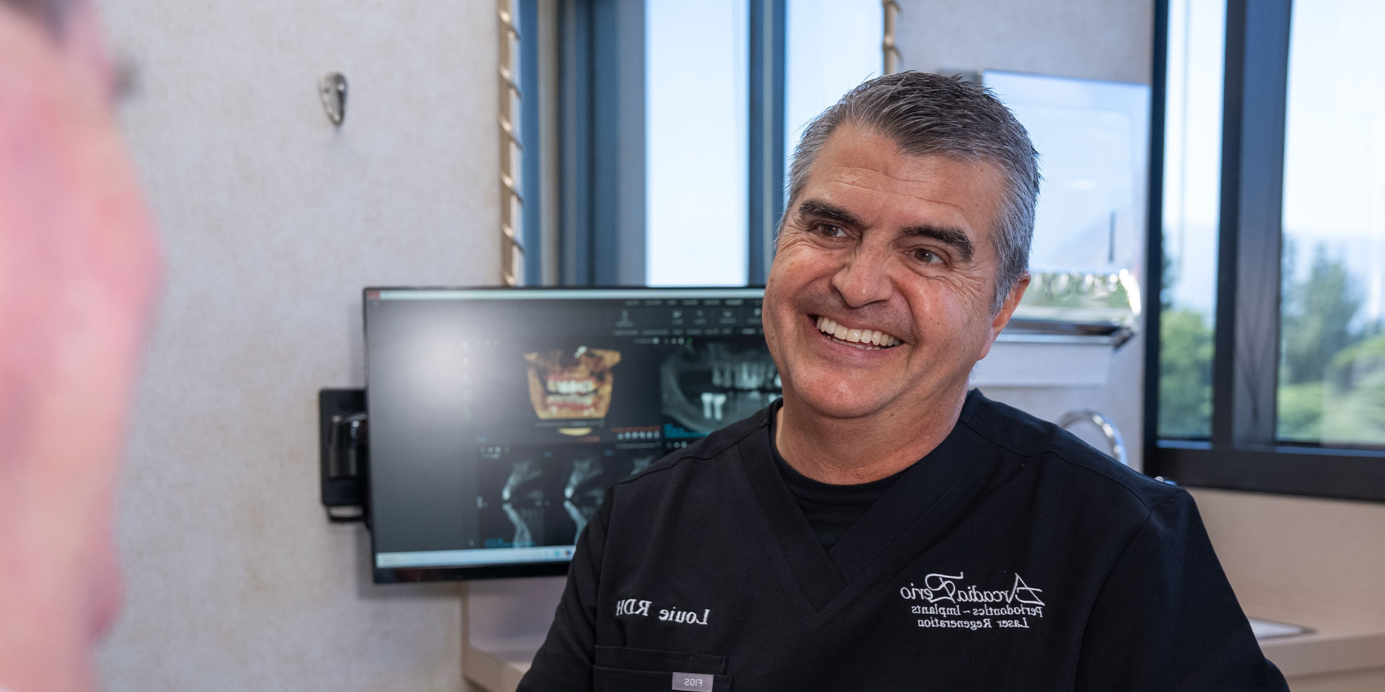 headshot of doctor smiling while going over dental procedure information
